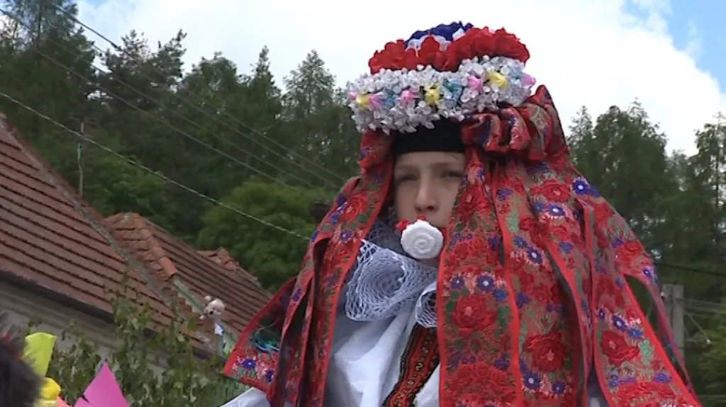 Král je převlečený za dívku a v ústech má růži