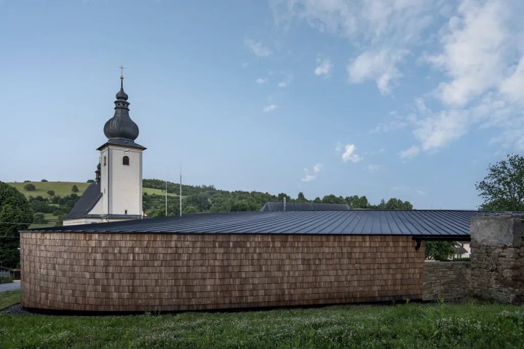 Reprezentativní veřejný prostor před kostelem slouží církevnímu i obecnímu setkávání. Následuje cesta kolem zastřešeného veřejného prostoru, venkovního předsálí až k zadní terase zahrnující torzo zdi bývalého hospodářství. Terasa nabízí místo jak pro farnost (obřady), tak pro obecní spolky či organizace