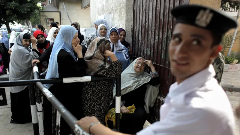 Před volebními místnostmi se místy tvoří fronty.