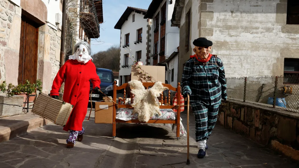 Maskovaní vesničané táhnou postel na karnevalové oslavy