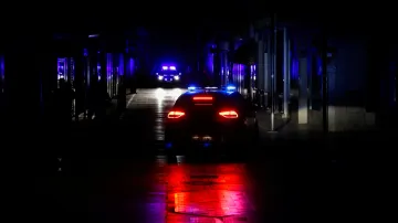 Policejní vůz hlídkuje v nákupní ulici bez elektrického osvětlení, aby zabránil krádežím a rabování v obchodech během výpadku proudu, který zasáhl velkou část Španělska
