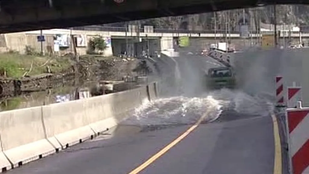 Auto projíždí částečně zaplavenou silnici