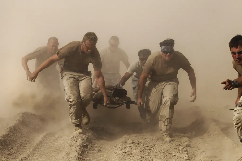 Příslušníci amerického námořnictva přepravují zraněného kolegu v provincii Kandahár, 2. října 2010