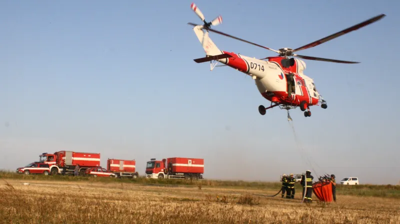 Hasiči likvidují požár pole a lesa u Manětína