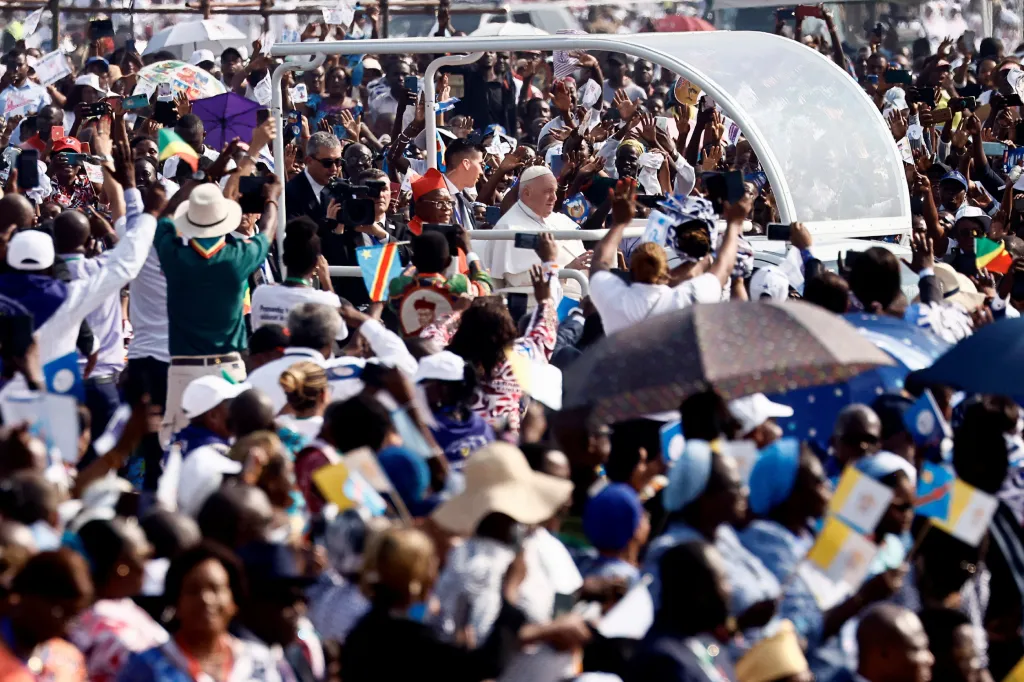 Papeže Františka, který projíždí ve svém papamobilu, zdraví lidé u místního letiště