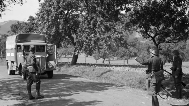 Dobový popisek: K výtržnostem henleinovců v sudetském území – Čs. vojenská silniční hlídka staví jedno z přijíždějících nákladních aut.