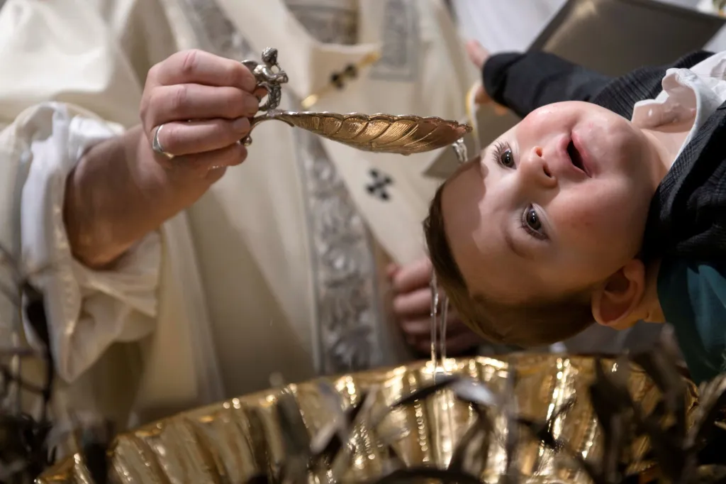Papež František křtí dítě během mše v Sixtinské kapli ve Vatikánu
