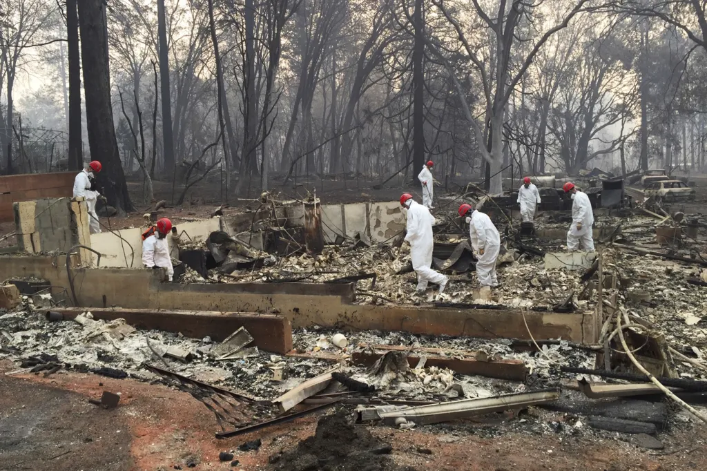 Dobrovolní záchranáři hledají pohřešované v troskách domů města Paradise spálených při požáru Camp Fire v Kalifornii. Úřady ještě dlouho po požáru zaznamenávaly stovky zpráv lidí, kteří se neuměli spojit se svými blízkými.