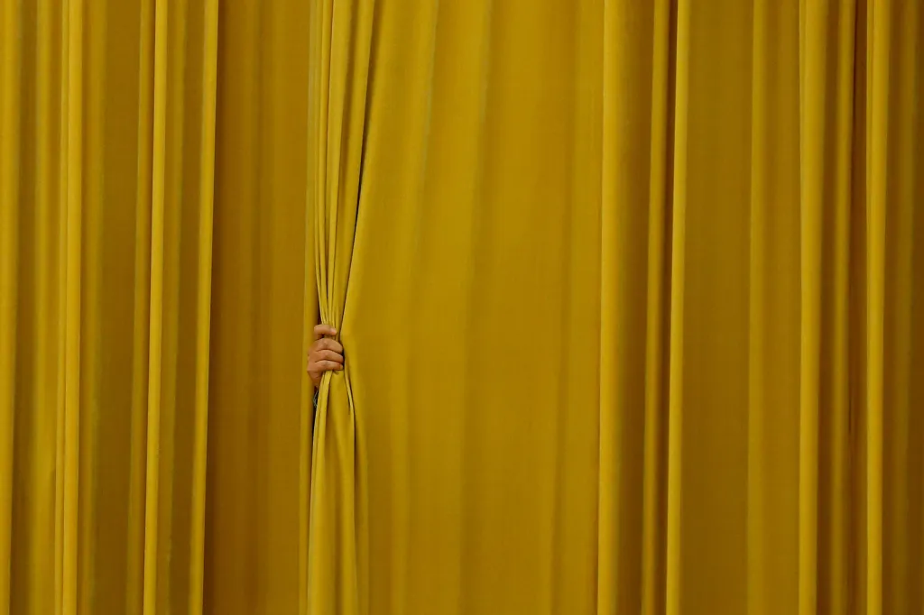 Úředník držící zataženou oponu čeká na vhodný moment k jejímu rozhrnutí u příležitosti slavnostního uvítání ruského premiéra Medveděva ve Velkém sále lidu v Pekingu a setkání s čínským premiérem Li Kche-čchiangem.