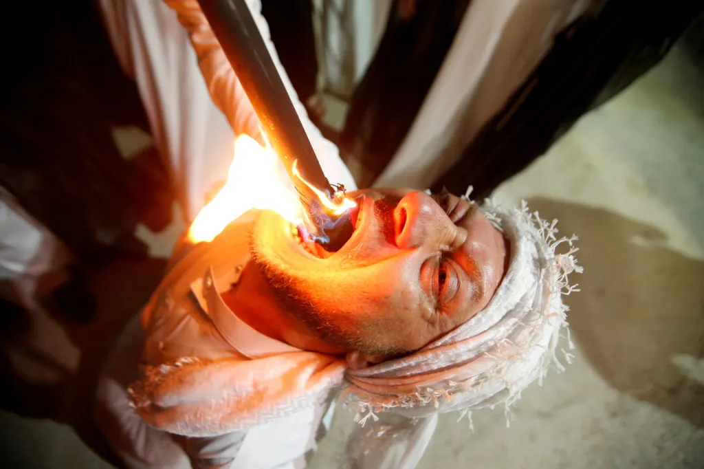 Během ramadánu si člen iráckých súfijských dervišů vkládá rituálně pochodeň s ohněm do úst ve městě Erbil