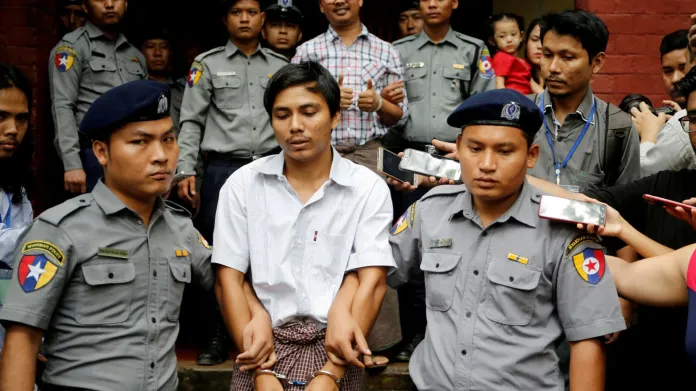 Zadržené novináře agentury Reuters po soudním slyšení v myanmarské metropoli Rangún odváží policie (20. srpna 2018)