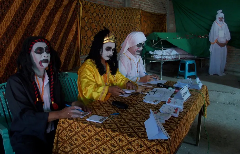 Úředníci volební komise oděni za duchy během voleb ve vesnici Randusari na ostrově Jáva v Indonésii