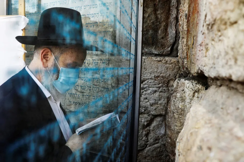 Ortodoxní žid se modlí u Zdi nářků za zastavení šíření choroby covid-19 ve starém městě Jeruzaléma