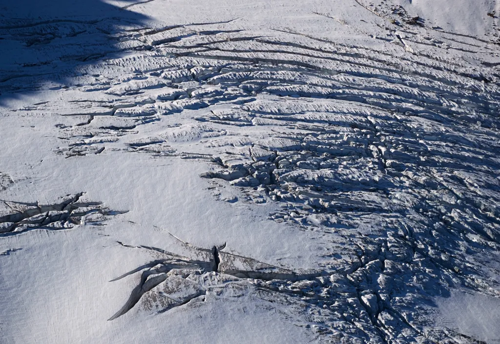 Praskliny, které oznamují destrukci ledovce, jsou viditelné v Trientu ve Švýcarsku. Snímek je pořízen v září 2019