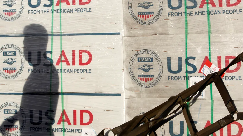 Stín příslušníka filipínské armády na bednách s humanitární pomocí od americké agentury USAID