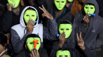 Lidé v maskách v indickém Ahmadábádu odpočítávají půlnoc