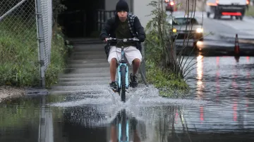 Cyklista projíždí po zaplaveném chodníku v kalifornském Haywardu