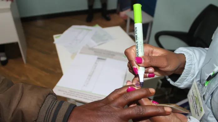 Pracovník u volebních uren v Keni označuje barvou člověka, který už odvolil