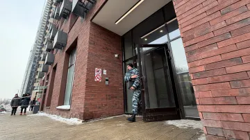 Policista vychází z obytné budovy v Moskvě, kde došlo k postřelení generálporučíka Vladimira Alexejeva