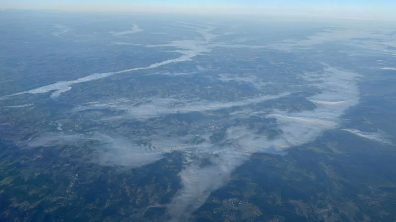 Při pohledu z letadla je dobře vidět, jak mlha teče korytem řek