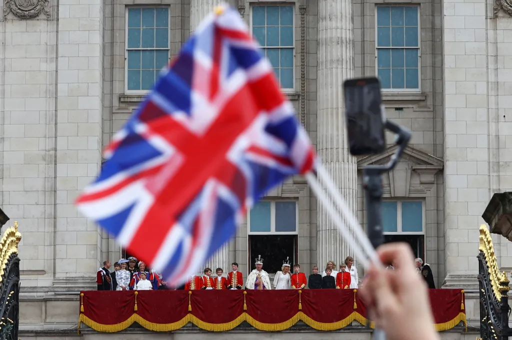 Lidé před Buckinghamským palácem zdraví čerstvě korunovaný královský pár