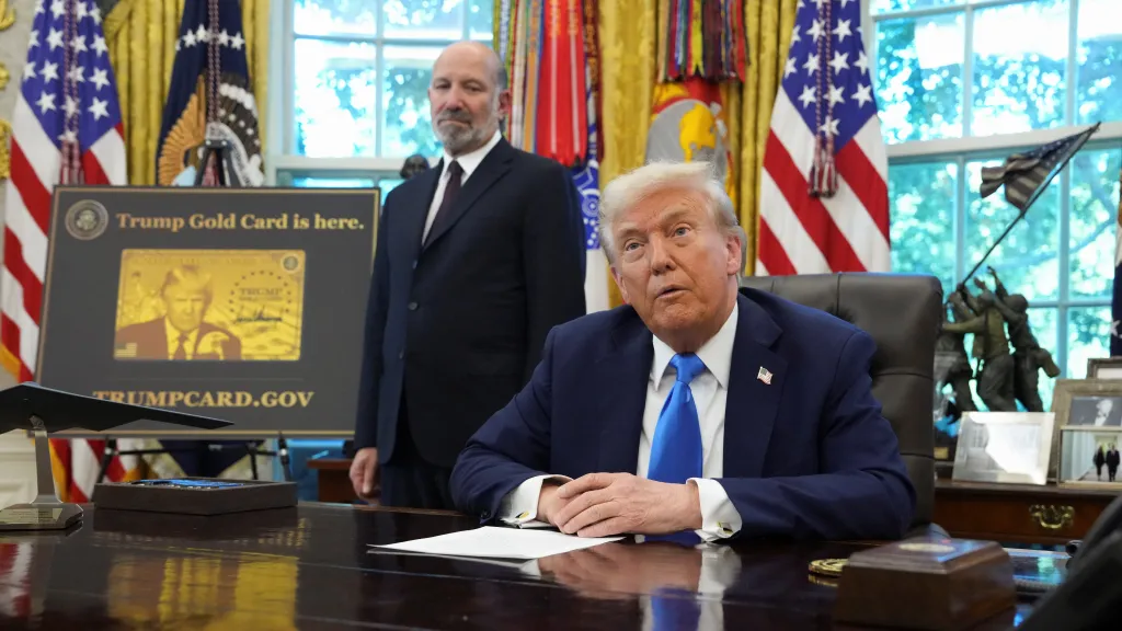 Americký prezident Donald Trump a americký ministr obchodu Howard Lutnick. Za nimi je vidět nápis „Trump Gold Card is here“ (Trumpova zlatá karta je tady), 19. září 2025, Washington