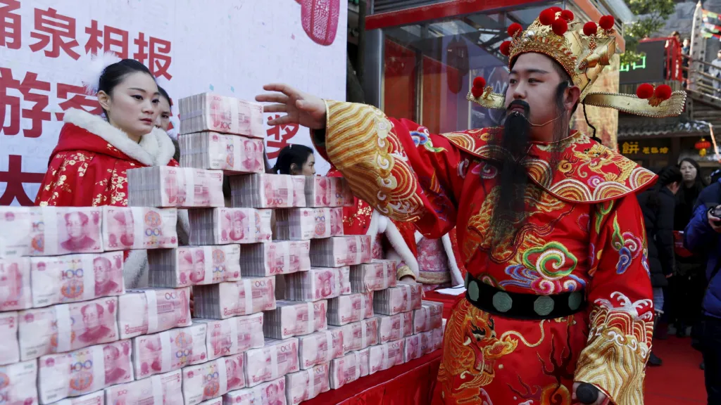 Muž oblečený jako čínský bůh bohatství v rámci oslav jarních svátků