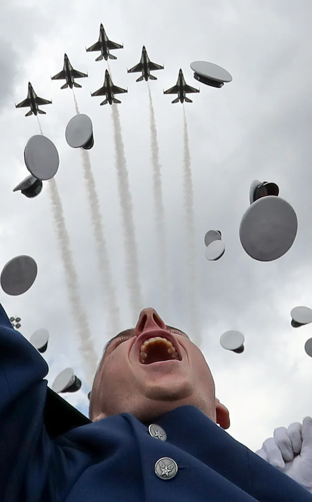Američtí vojenští kadeti tradičně vyhazují své čepice poté, co obdrželi diplom na Air Force Academy v Colorado Springs v Coloradu