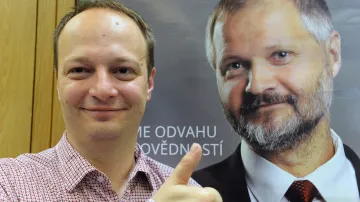 Nově zvolený senátor Václav Láska u volebního plakátu Václava Hampla