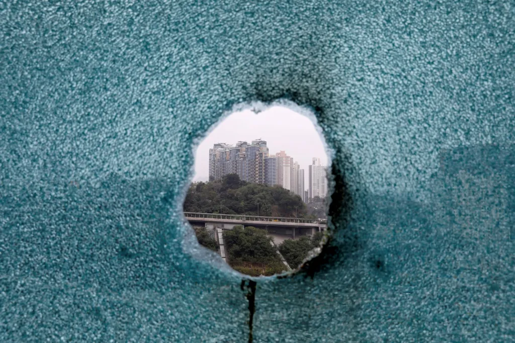 Průstřel v okně způsobený policejní střelou na polytechnické univerzitě v Hongkongu, kde se zabarikádovala skupina studentů
