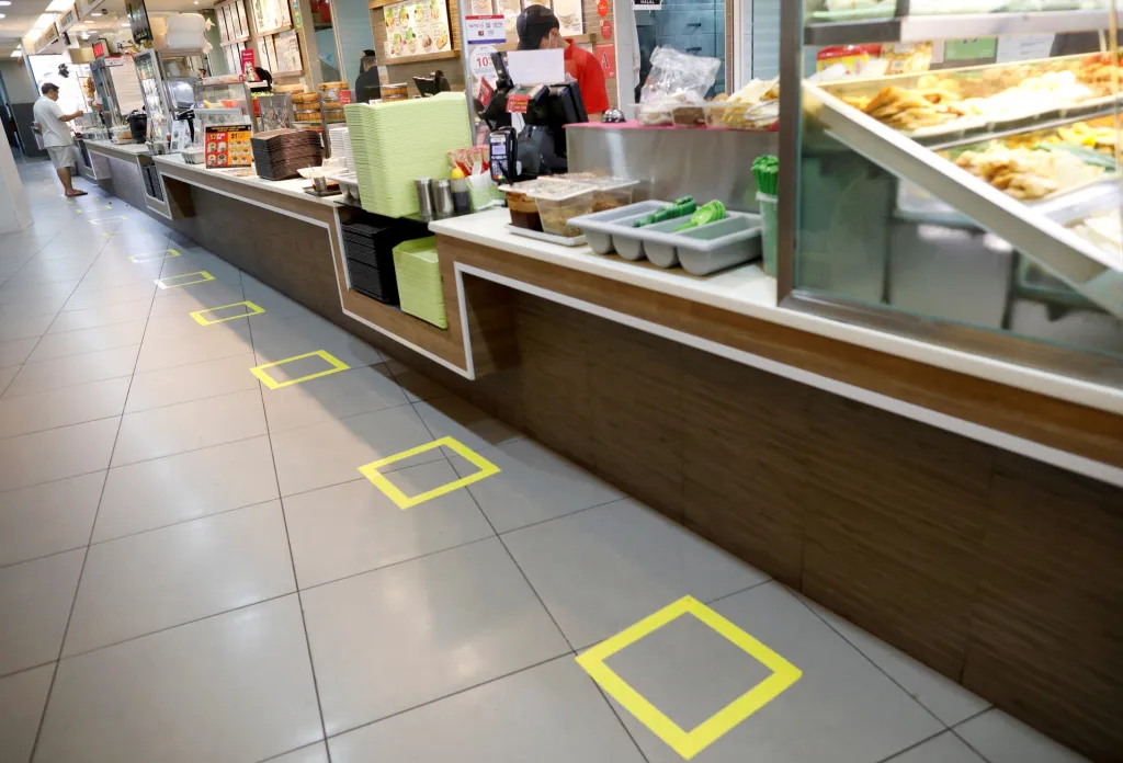 Páskou vyznačená místa pro klienty restaurace v singapurském obchodním centru