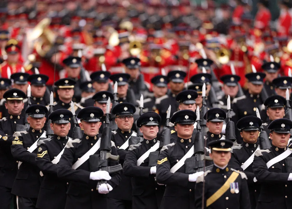 Vojáci doprovází královský kočár z Westminsterského opatství do Buckinghamského paláce