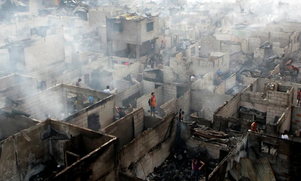 Obyvatelé prohrabávají trosky svých domů po obřím požáru ve městě Makati na Filipínách 19. dubna 2011