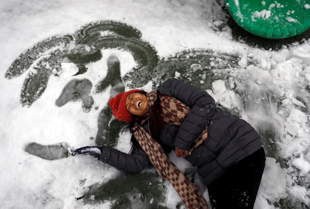 Smích z úst nevzal ženě ani pád na čerstvě zasněžené cestě v kopcích Chandragiri v Káthmándú v Nepálu
