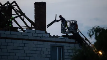 Dělníci opravují střechu domu poškozenou částí dronu v polské obci Wyryki