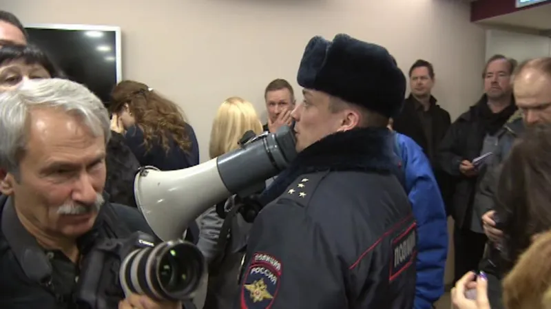 Policista žádá novináře, aby vyklidili sál