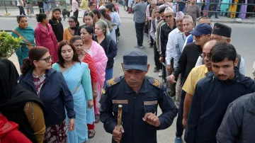Příslušník nepálské policie dohlíží na frontu před volební místností