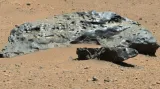 První nález meteoritu, který sonda Curiosity na Marsu učinila. Tyto železné meteority, nazvané Lebanon (větší kámen) a Lebanon B (menší kámen v popředí), obejvilo vozítko 25. května 2014. Větší kámen Lebanon je široký téměř dva metry