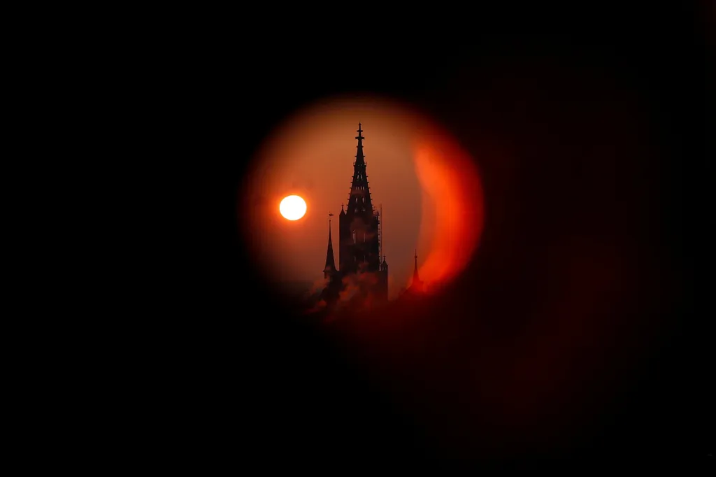 Východ slunce za katedrálou Muenster během mrazivého rána ve švýcarském Bernu
