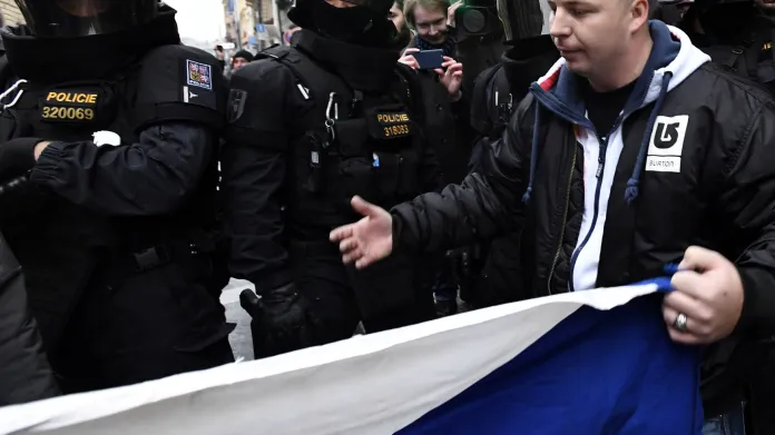 Účastníci průvodu DSSS v pražské Hybernské ulici, kam vyrazili z dolní části Václavského náměstí. Policie v ulici zastavila provoz a společně s antikonfliktním týmem bránila účastníkům pochodu opustit původně plánovanou trasu pochodu.
