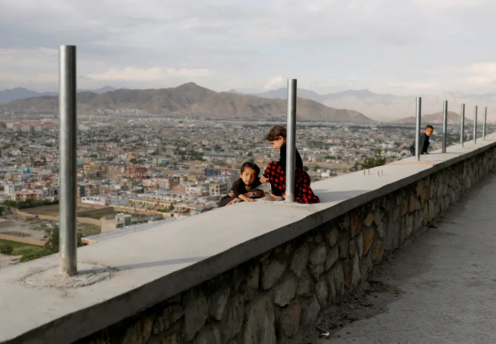 Dvě malé dívky si hrají na zdi nad Kábulem