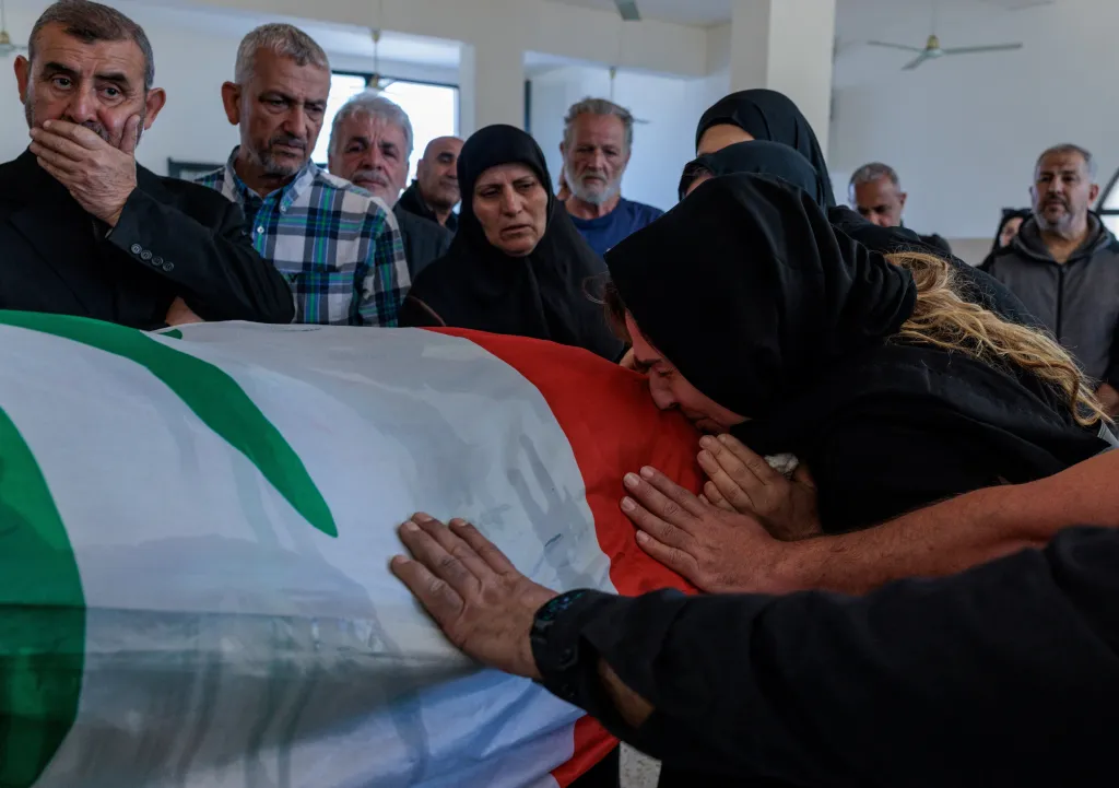 Žena během pohřbu oplakává svého otce Husseina Dbouka, jehož tělo se podařilo vyprostit z trosek domu ve městě Tyre na jihu Libanonu, který byl zasažen během izraelského útoku