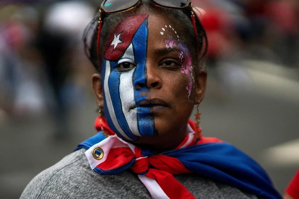Kubánská emigrantka protestuje v Miami v USA proti režimu na Kubě. Demonstrovalo se i v dalších amerických městech. Na dálku tak kubánské komunity podporují své krajany, kteří vyšli do ulic kvůli zoufale špatné hospodářské situaci