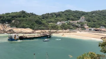 Zadržená čínská bagrovací loď vrací písek na Ma-cu