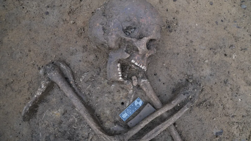 Detail pohřbu bojovníka s nátepní destičkou, která chránila zápěstí lučištníků před zraněním způsobeným tětivou luku