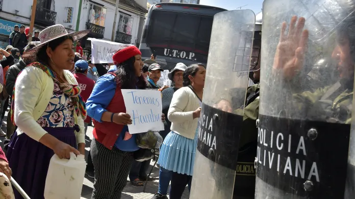 Protest kvůli ekonomické krizi, žena drží transparent s nápisem „máme hlad“