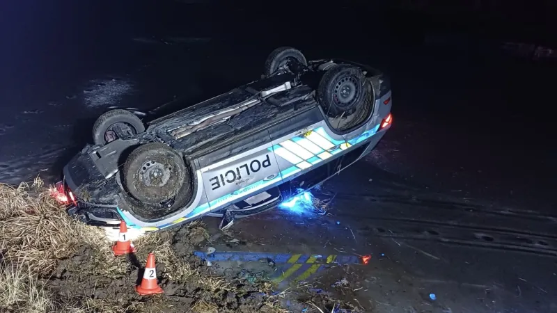 Převrácené policejní auto, které sjelo ze svahu