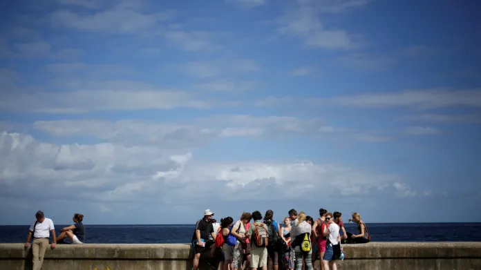 Turisté na hlavním pobřežním bulváru Malecon v Havaně
