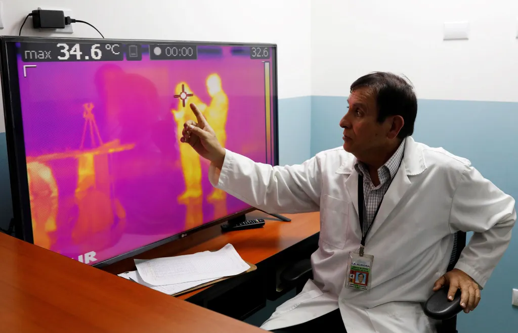 Lékař u scanneru tělesné teploty na letišti ve Guatemala City