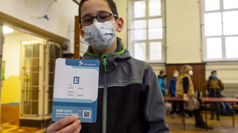 Žák základní školy Chabařovice na Ústecku ukazuje  v tělocvičně školy výsledek testu na koronavirus